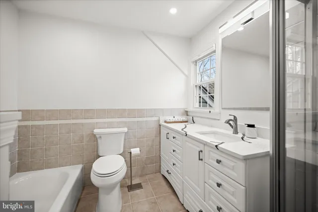 a bathroom with a toilet a sink a tub and mirror