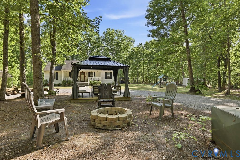 5307 St Pauls Church Road Goochland, VA 23063 - Photo 36 of 44 a view of a patio with table and chairs potted plants and large tree
