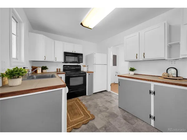 a kitchen with kitchen island sink stove and refrigerator