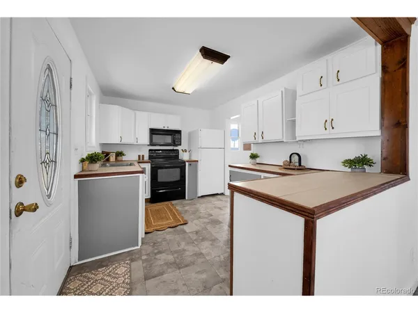 a kitchen with kitchen island white cabinets and refrigerator