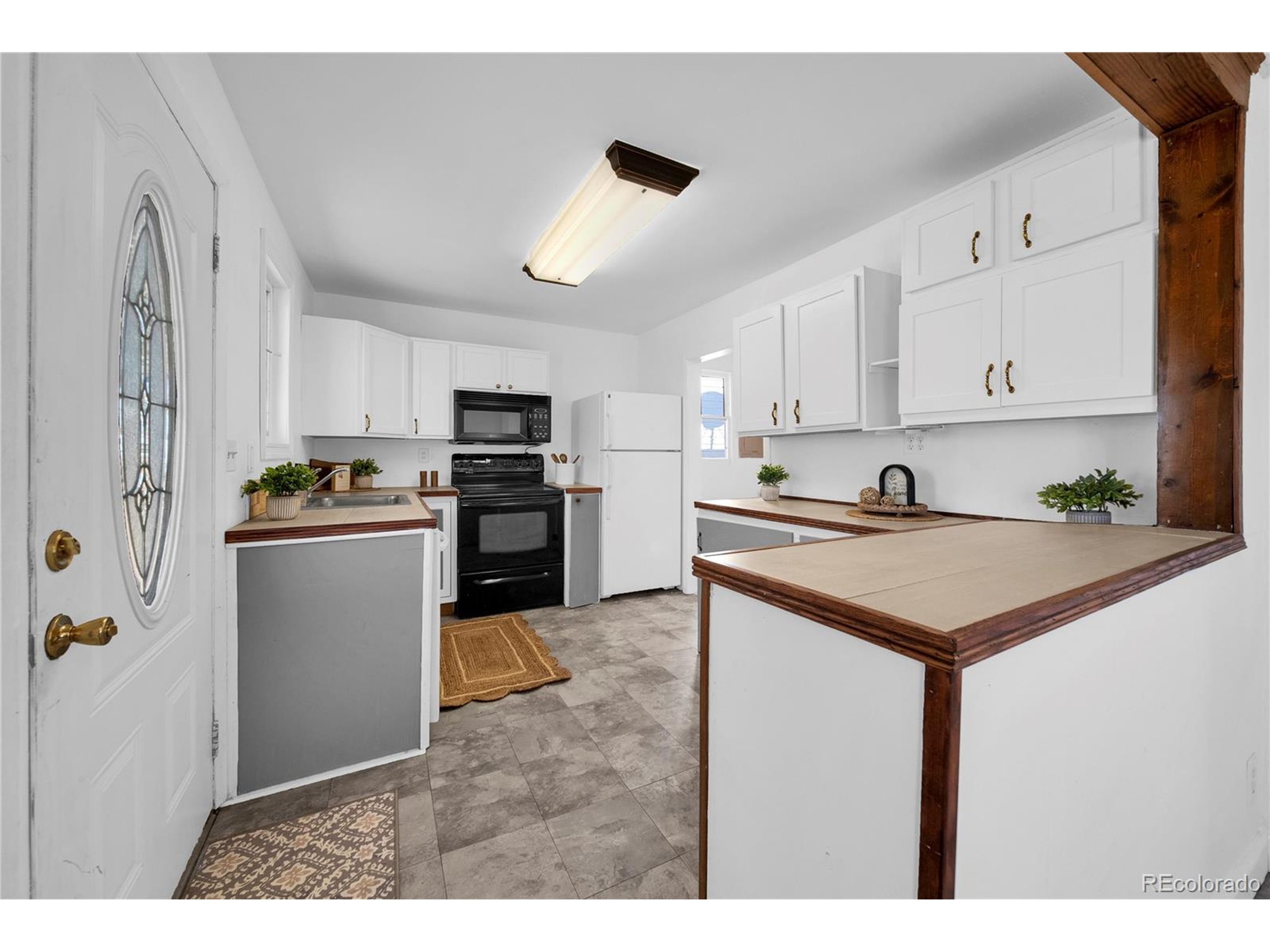 701 4th Street Akron, CO 80720 - Photo 16 of 26 a kitchen with kitchen island white cabinets and refrigerator