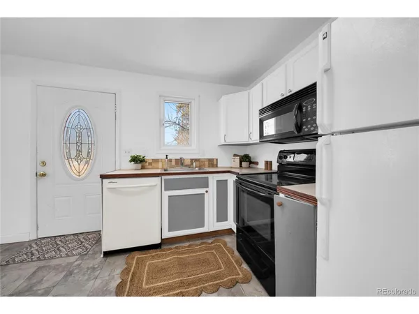 a kitchen with granite countertop a refrigerator stove top oven and sink