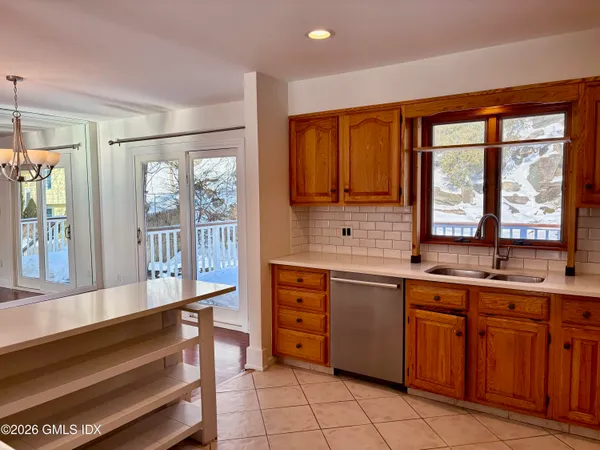 a large kitchen with kitchen island granite countertop a large window and cabinets