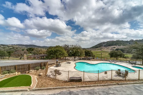 a view of a swimming pool with lawn chairs