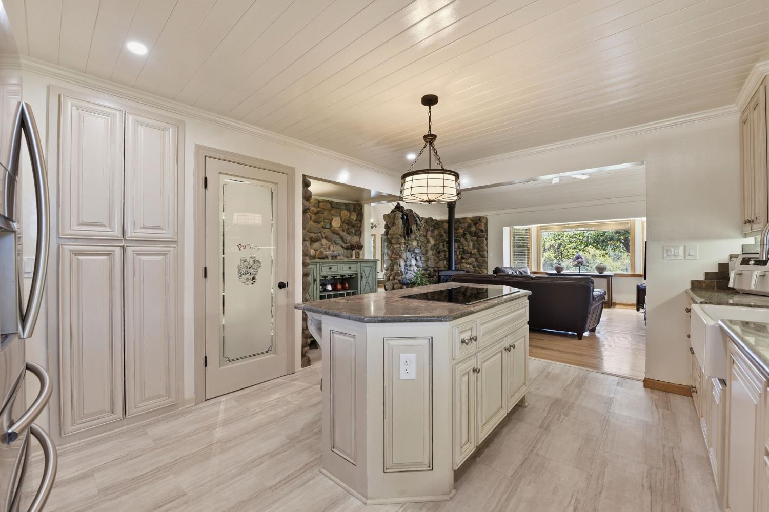 7201 Happy Valley Road Somerset, CA 95684 - Photo 18 of 75 Kitchen featuring a central island with an integrated cooktop and pendant lighting, along with a pantry closet and pantry cabinetry.