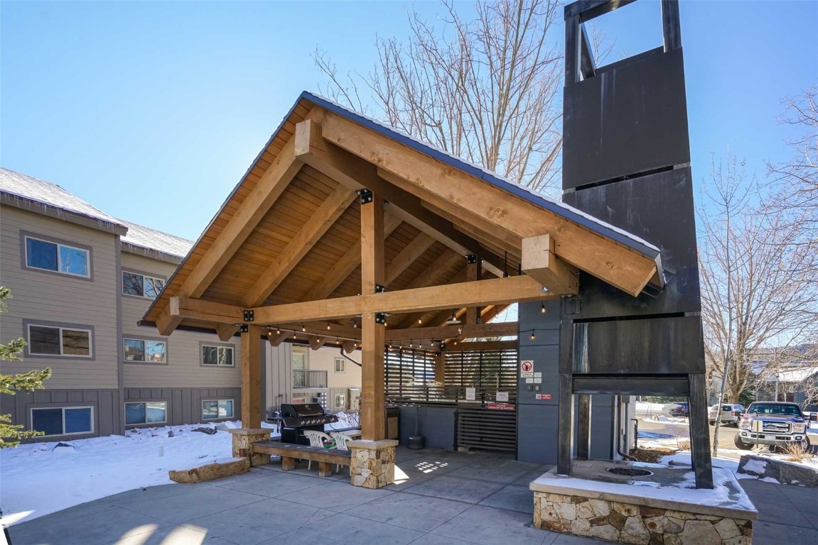 1565 Shadow Run Frontage, Unit B307 Steamboat Springs, CO 80487 - Photo 19 of 20 a view of patio with a table and chairs under an umbrella with wooden fence