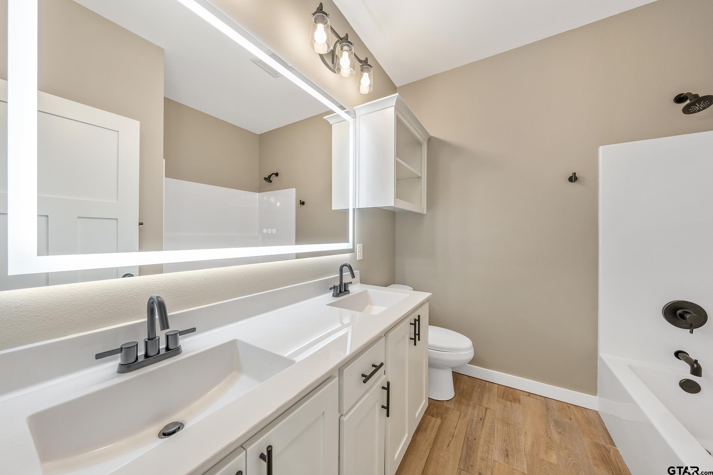 16418 Crossing Circle Lindale, TX 75771 - Photo 21 of 31 a bathroom with a sink a toilet a shower and a mirror