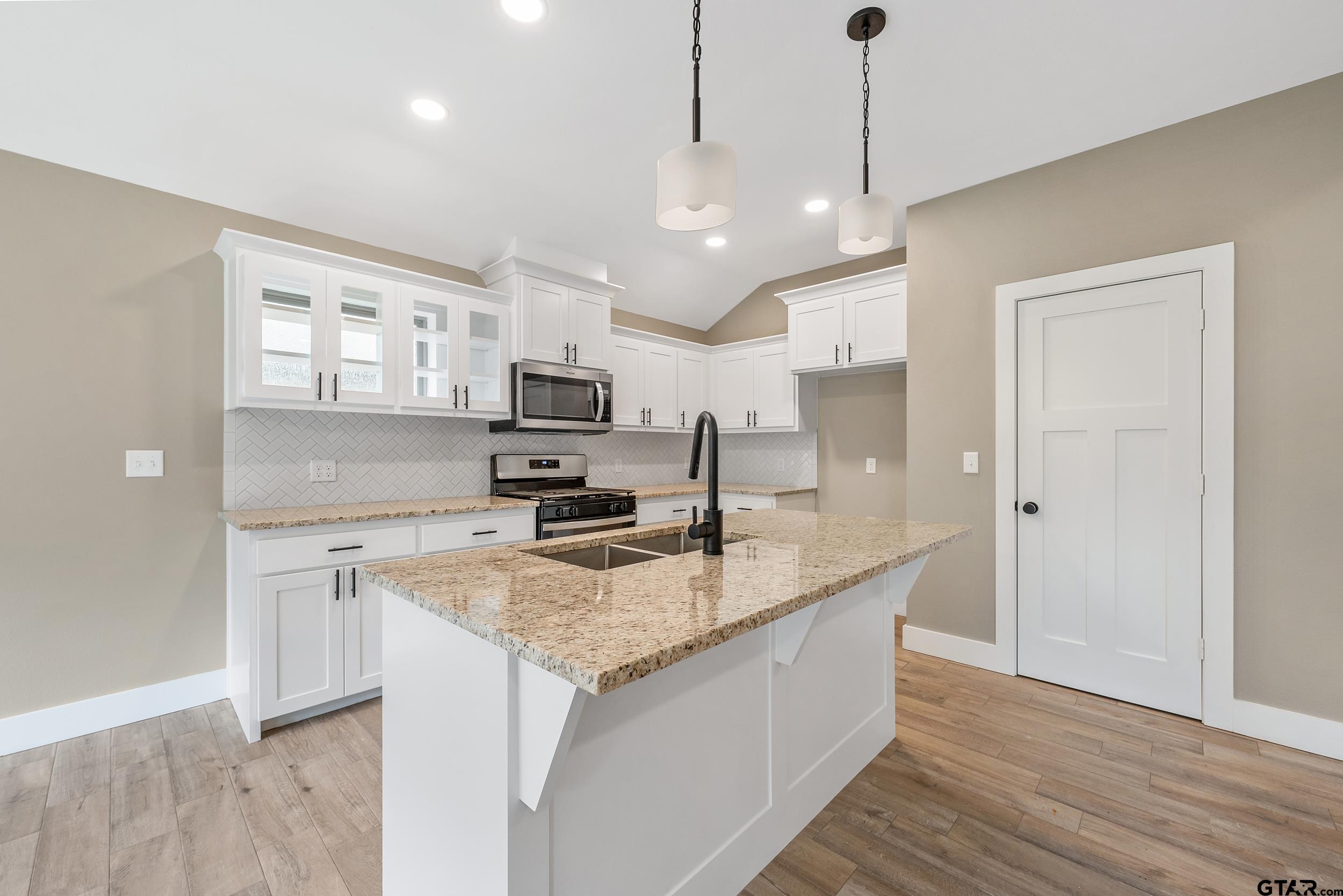 16418 Crossing Circle Lindale, TX 75771 - Photo 7 of 31 a kitchen with stainless steel appliances granite countertop a sink stove and refrigerator