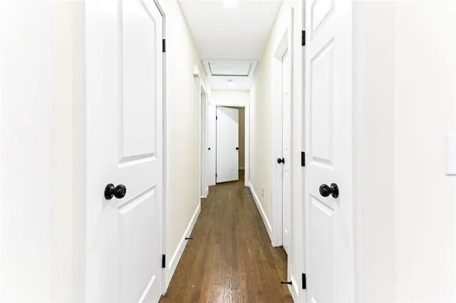 a view of a hallway with wooden floor and staircase