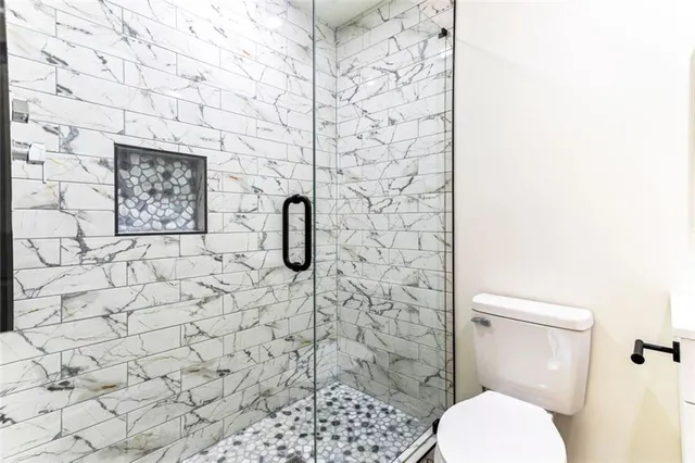 a bathroom with a toilet and a shower