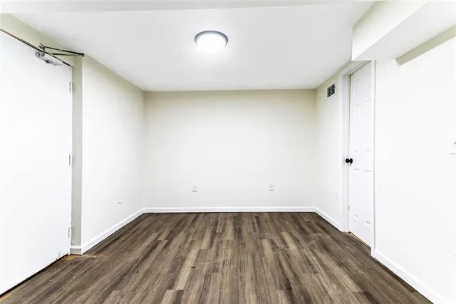 a view of a room with wooden floor and white walls