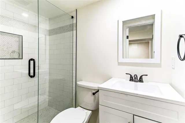 a bathroom with a sink a toilet and shower