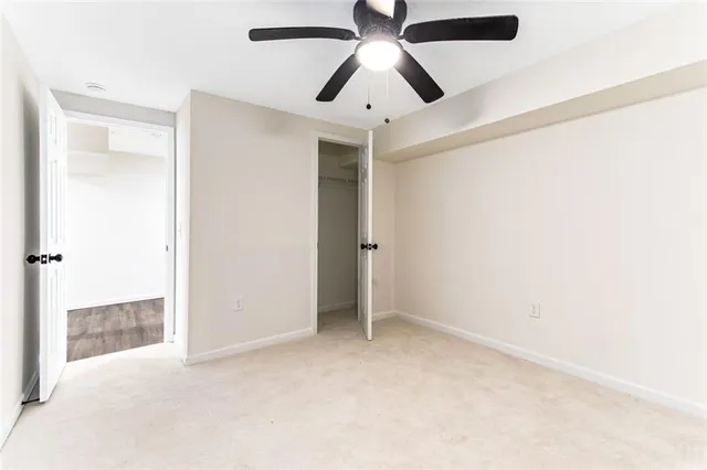 an empty room with closet and a chandelier fan