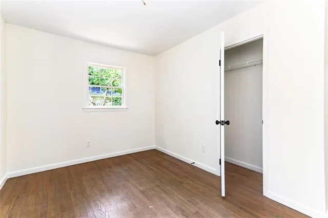 an empty room with wooden floor and closet