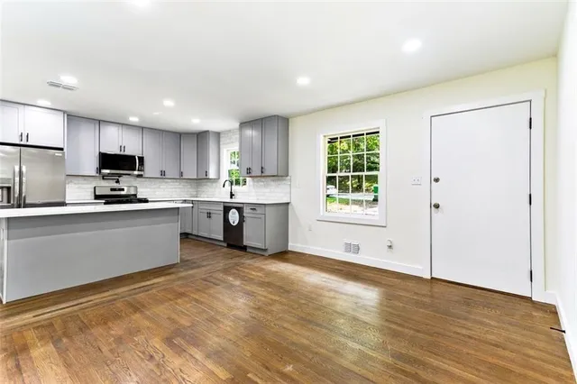 a kitchen with stainless steel appliances granite countertop a stove a sink and a refrigerator