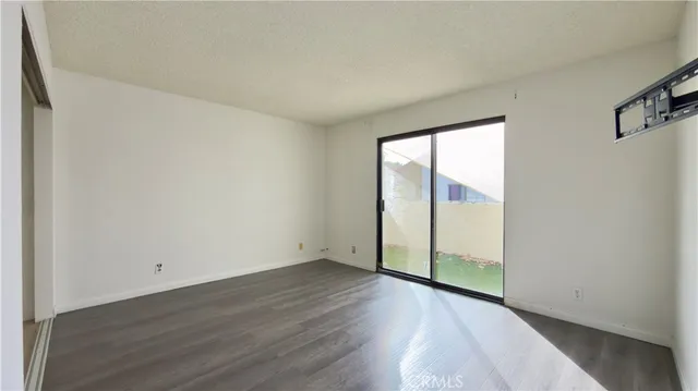 an empty room with wooden floor and sliding door