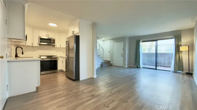 a view of kitchen with refrigerator microwave and stove