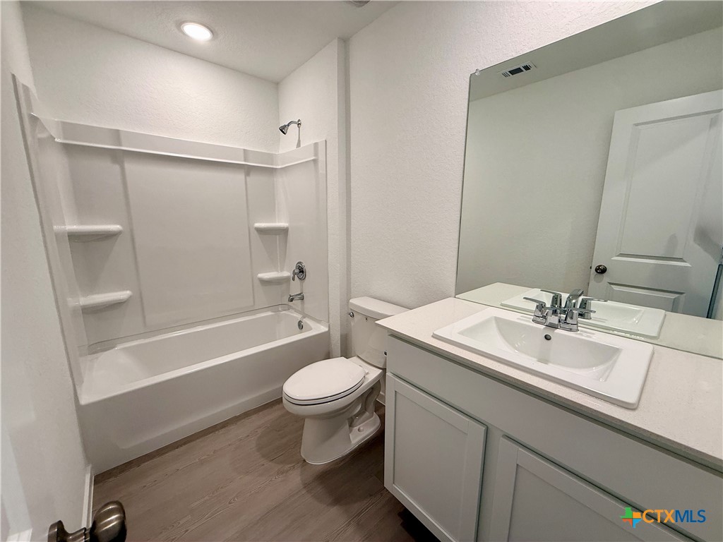 413 Moscato Road New Braunfels, TX 78130 - Photo 21 of 28 a bathroom with a sink toilet a mirror and shower