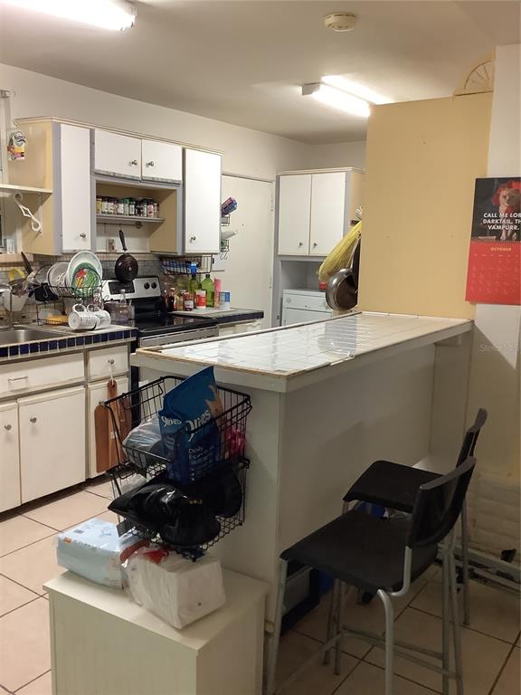 1906 Southwest 17th Court Miami, FL 33145 - Photo 13 of 33 a kitchen with a sink chairs and cabinets