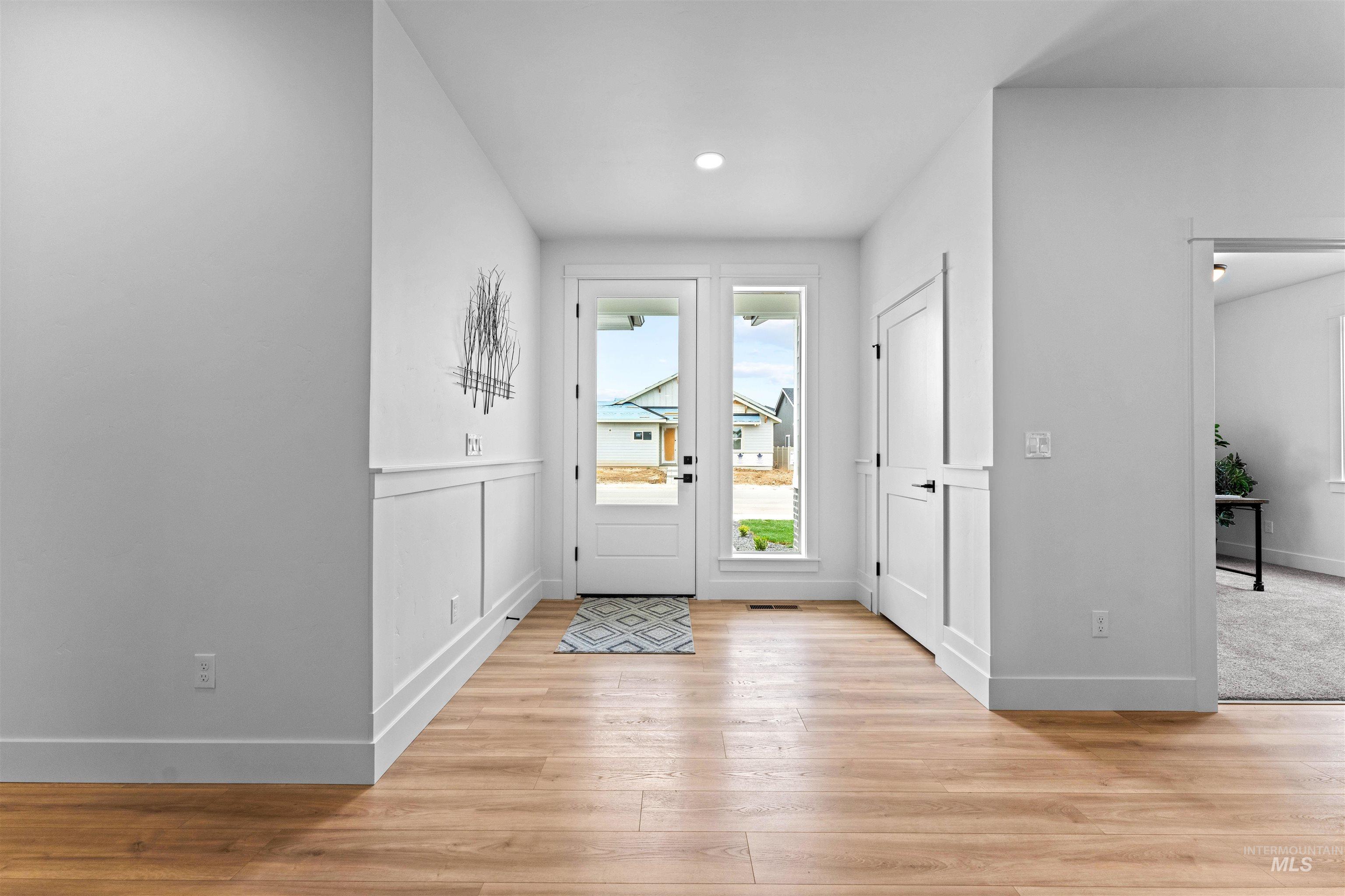 9943 West Sunberry Court Star, ID 83669 - Photo 6 of 25 Entryway with light wood finished floors, recessed lighting, and a wainscoted wall