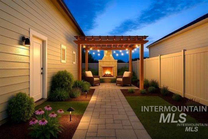 9943 West Sunberry Court Star, ID 83669 - Photo 10 of 25 Fenced backyard featuring a patio area, a warm lit fireplace, and a pergola