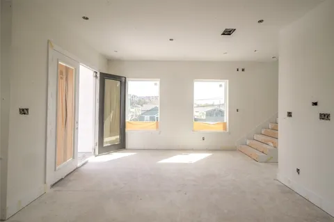 a view of a hallway with wooden floor and windows