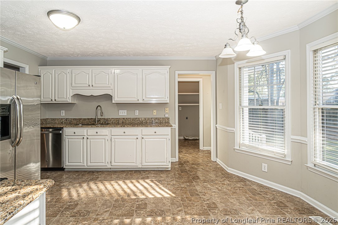 7787 Trappers Road Fayetteville, NC 28311 - Photo 12 of 47 a kitchen with granite countertop a stove a sink and a refrigerator