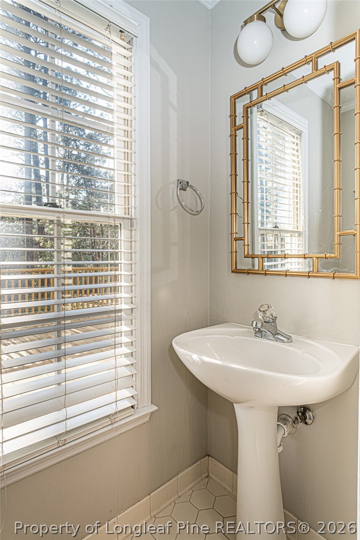 7787 Trappers Road Fayetteville, NC 28311 - Photo 19 of 47 a bathroom with a sink a mirror and a window