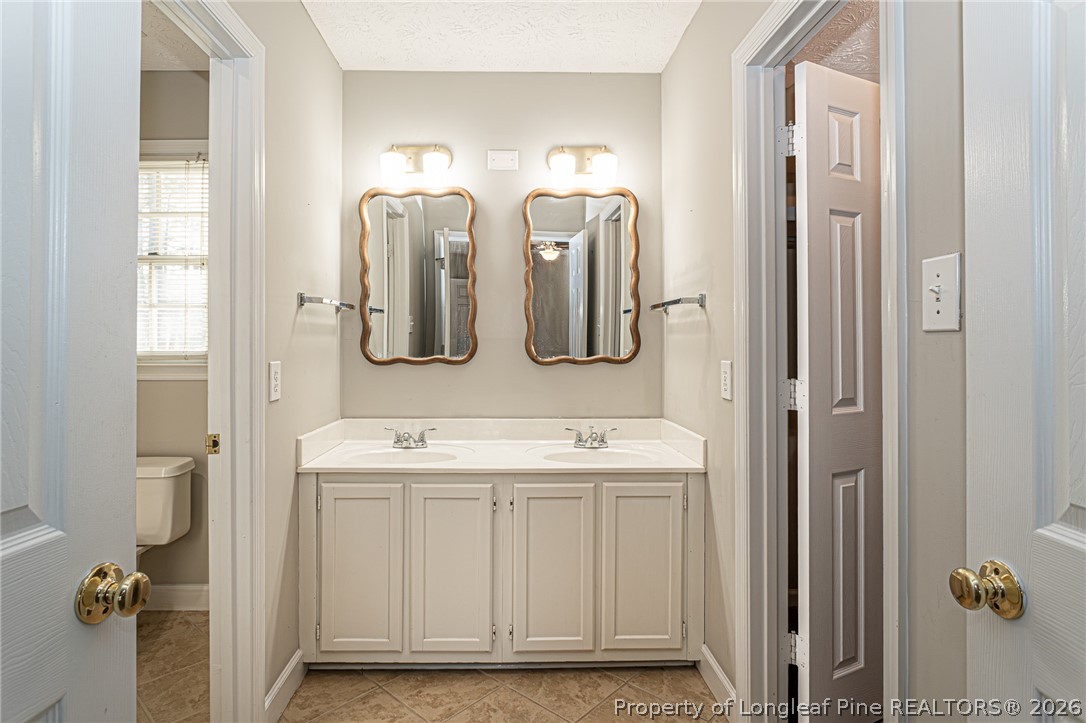 7787 Trappers Road Fayetteville, NC 28311 - Photo 23 of 47 a bathroom with double vanity sinks and a mirror