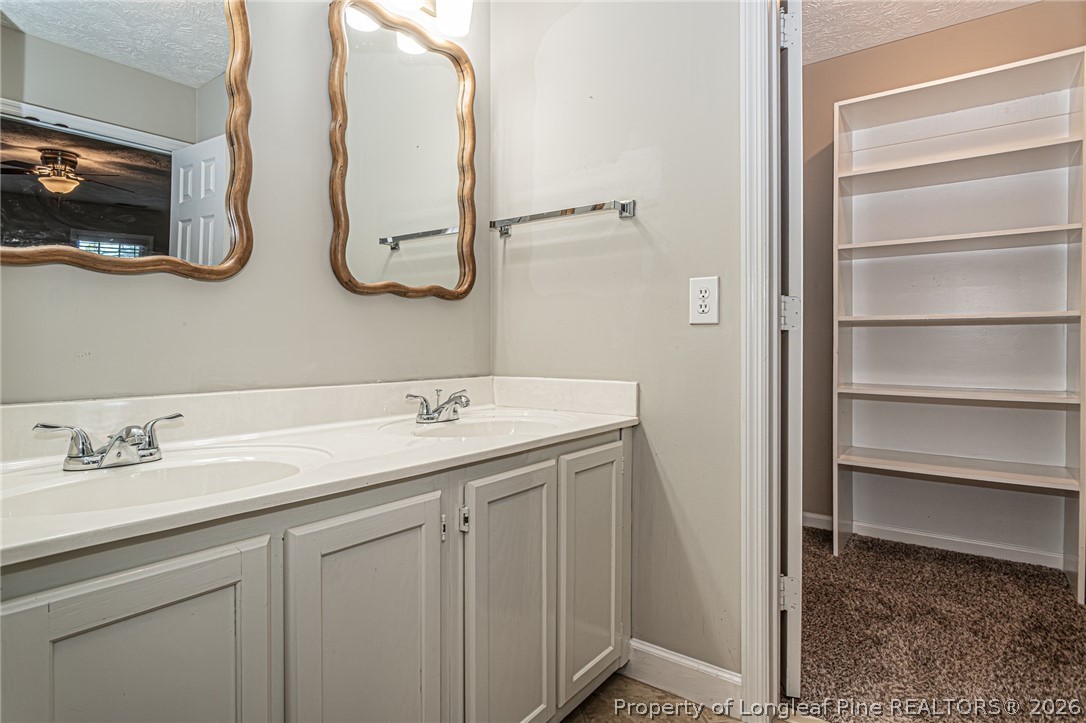 7787 Trappers Road Fayetteville, NC 28311 - Photo 25 of 47 a bathroom with a double vanity sink and a mirror