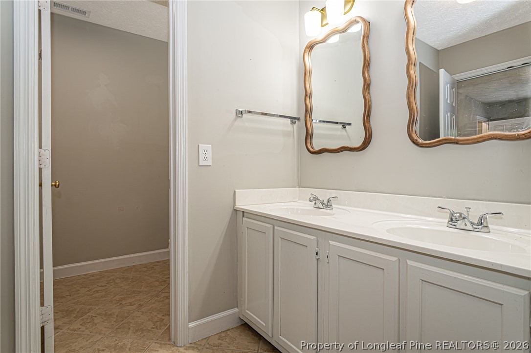 7787 Trappers Road Fayetteville, NC 28311 - Photo 26 of 47 a bathroom with a double vanity sink and mirror