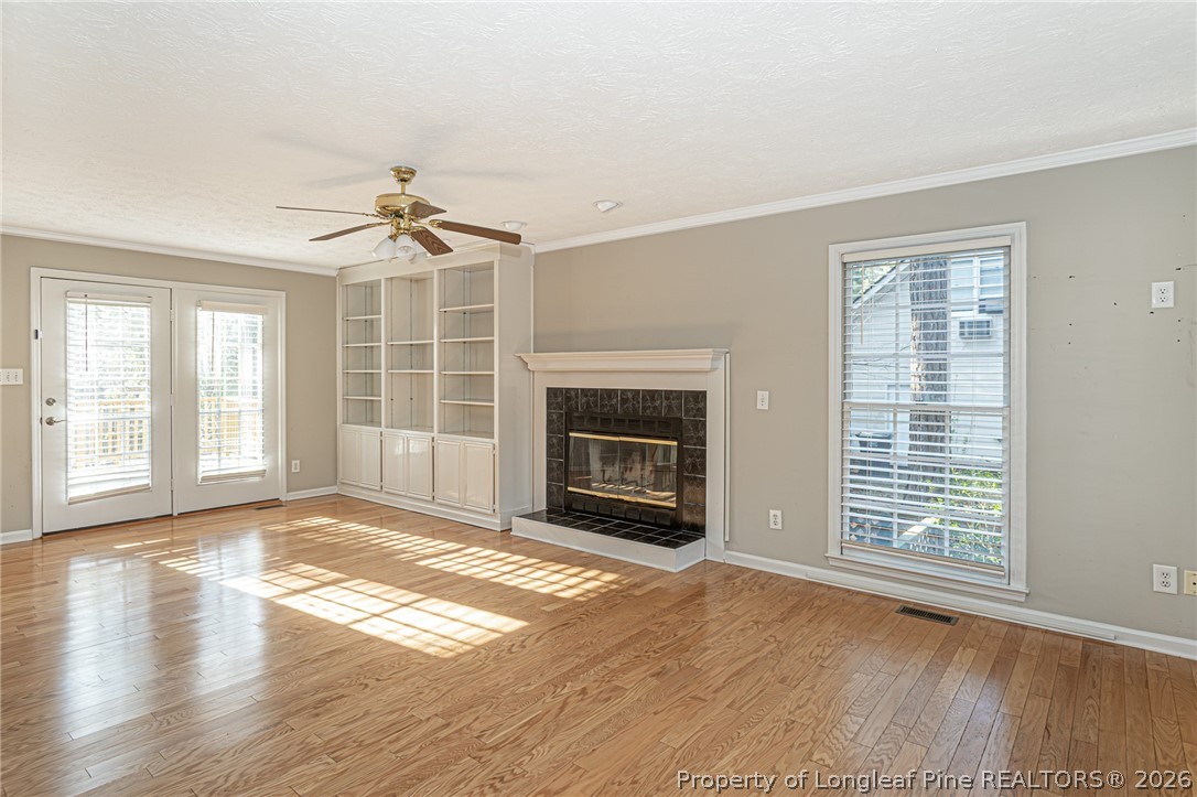 7787 Trappers Road Fayetteville, NC 28311 - Photo 7 of 47 a view of an empty room with wooden floor fireplace and a window