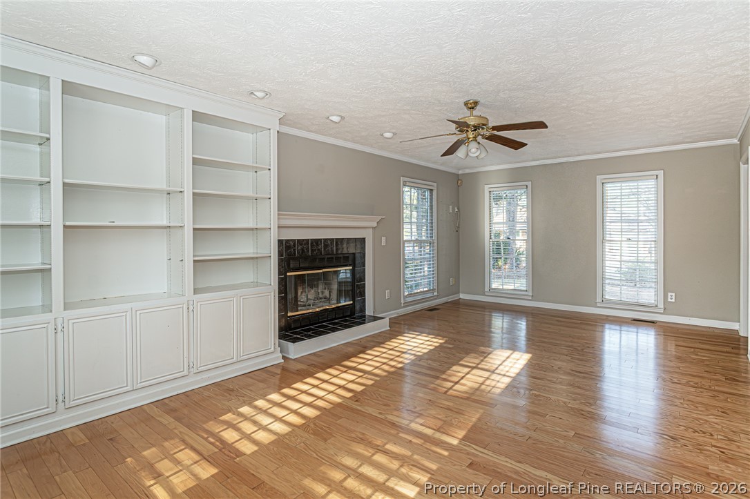 7787 Trappers Road Fayetteville, NC 28311 - Photo 9 of 47 a view of a livingroom with a fireplace a ceiling fan and windows
