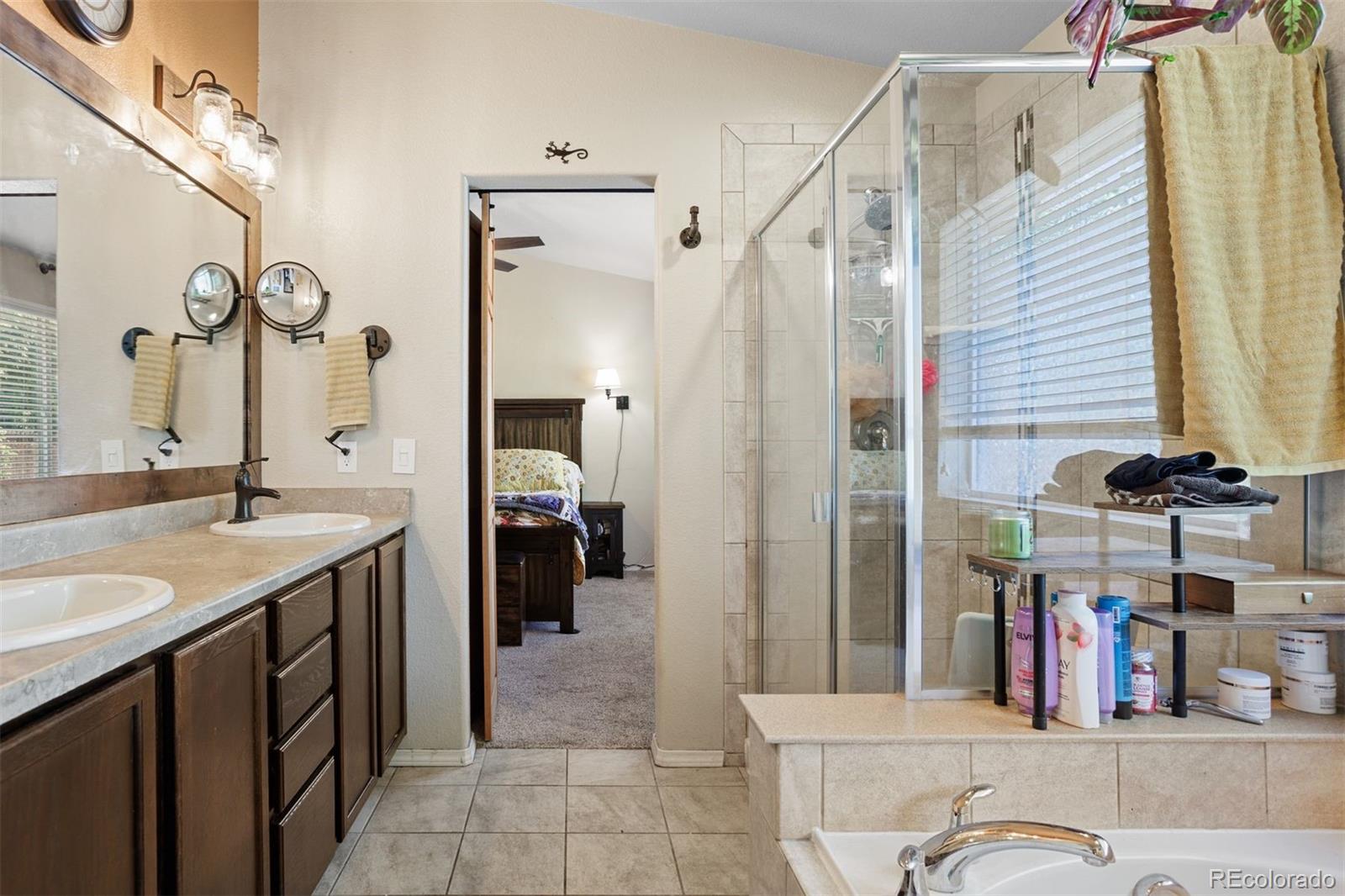 2556 Hannah Ridge Drive Colorado Springs, CO 80922 - Photo 16 of 39 a bathroom with a granite countertop sink and a mirror
