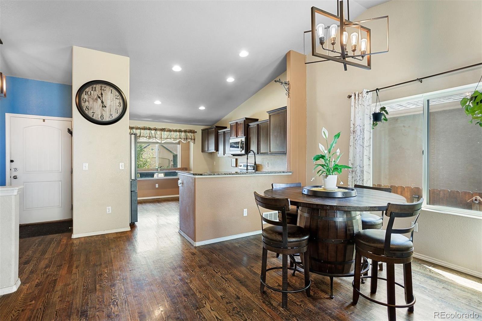 2556 Hannah Ridge Drive Colorado Springs, CO 80922 - Photo 6 of 39 a view of a dining room with furniture a chandelier and wooden floor