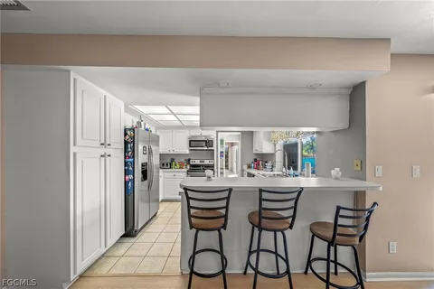 a kitchen with stainless steel appliances a dining table chairs and a refrigerator