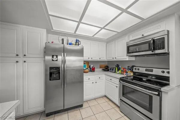 a kitchen with granite countertop a refrigerator and a stove top oven