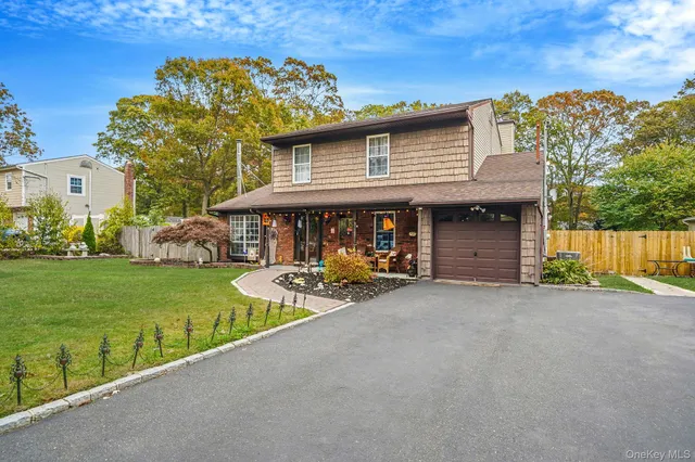 a view of a house next to a big yard and large trees