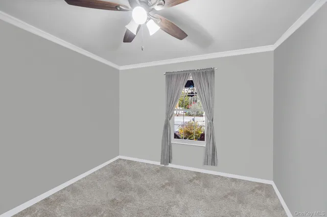an empty room with windows and ceiling fan