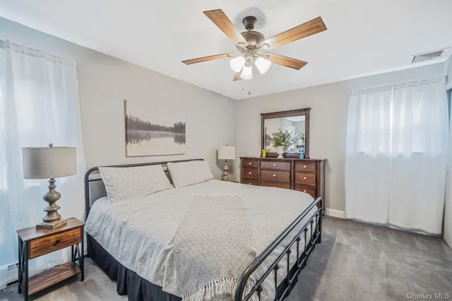 a spacious bedroom with a bed and a chandelier