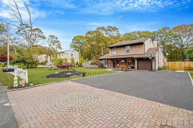 a front view of a house with a yard and ocean view