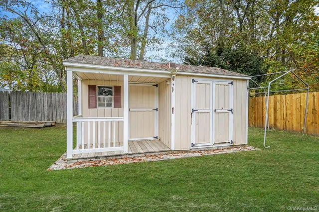 a view of a backyard with large trees and wooden fence