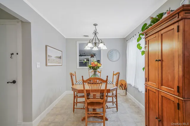 a dining room with furniture chandelier and a rug