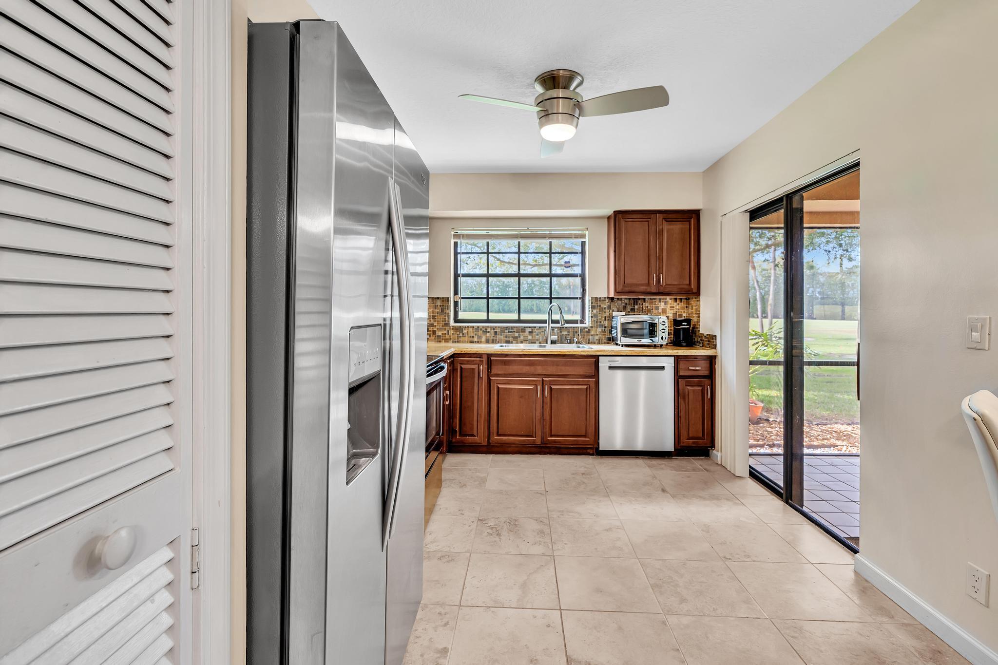 17372 Boca Club Boulevard, Unit 405 Boca Raton, FL 33487 - Photo 27 of 74 a kitchen with stainless steel appliances a stove top oven a sink a refrigerator and a window