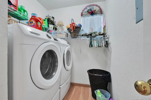a utility room with dryer washer and a view of living room