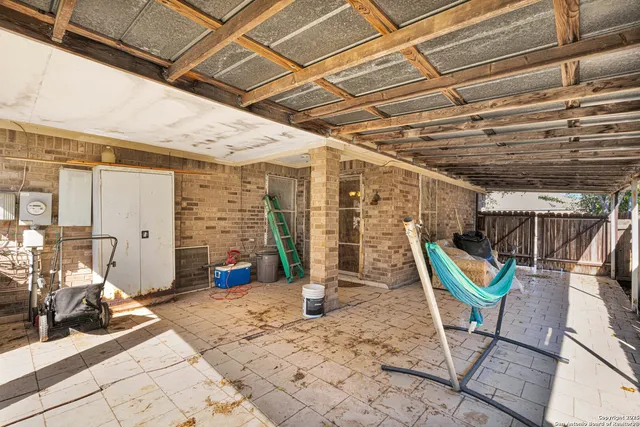 a view of backyard with wooden fence and a large tree