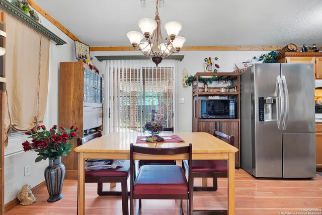 a outdoor dining room with furniture a chandelier and wooden floor