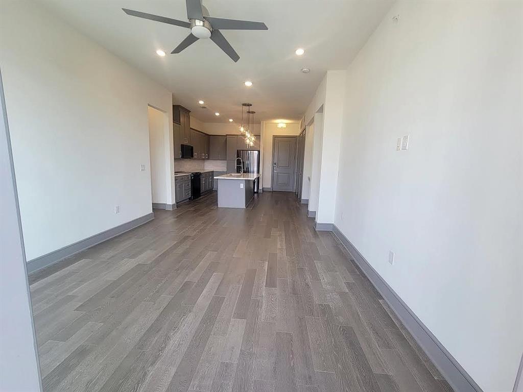 2700 Old Denton Road, Unit 4407 Carrollton, TX 75007 - Photo 5 of 34 a view of a livingroom with wooden floor and a ceiling fan