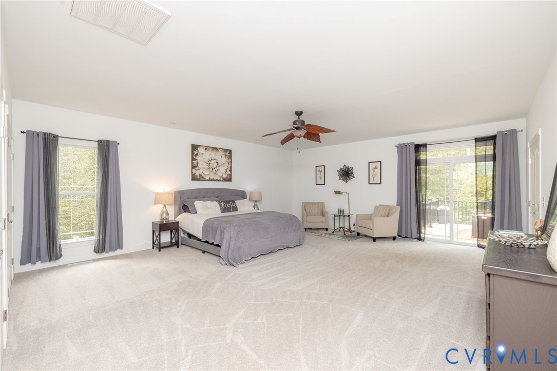 11081 Shannon Hill Road Louisa, VA 23093 - Photo 17 of 49 a spacious bedroom with a bed a table and large windows