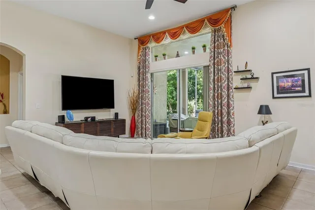 a living room with furniture kitchen view and a chandelier